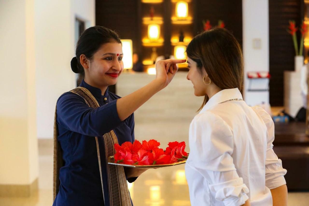 فندق تريدنت أغرا آغْرا المظهر الخارجي الصورة A hotel staff welcoming a guest